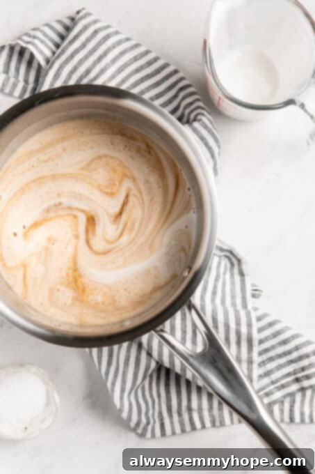 Simple Plant-Based Caramel 6 Brown sugar and coconut milk mixture cooking in a saucepan, beginning to bubble.