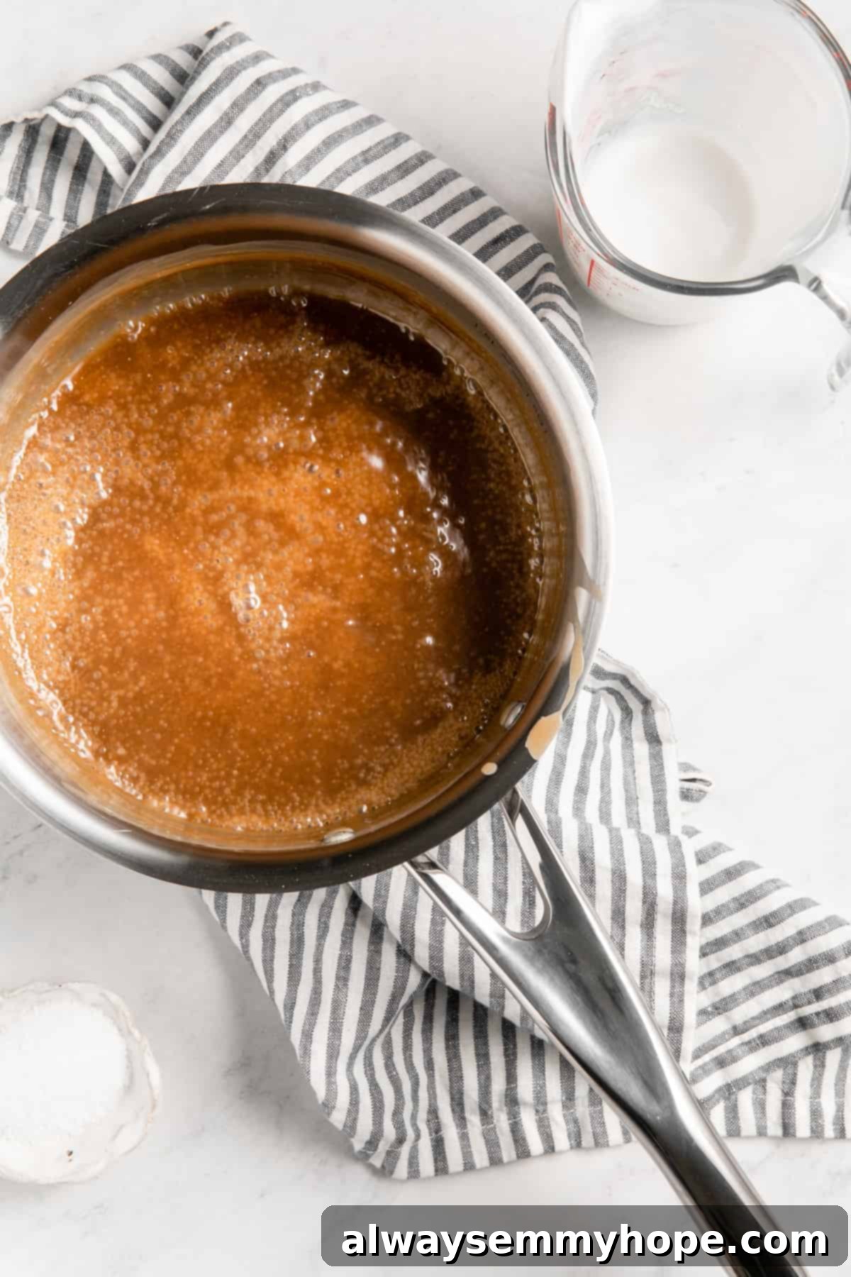 Simple Plant-Based Caramel 7 Vegan caramel sauce simmering gently in a saucepan, showing its golden color and slightly thickened consistency.