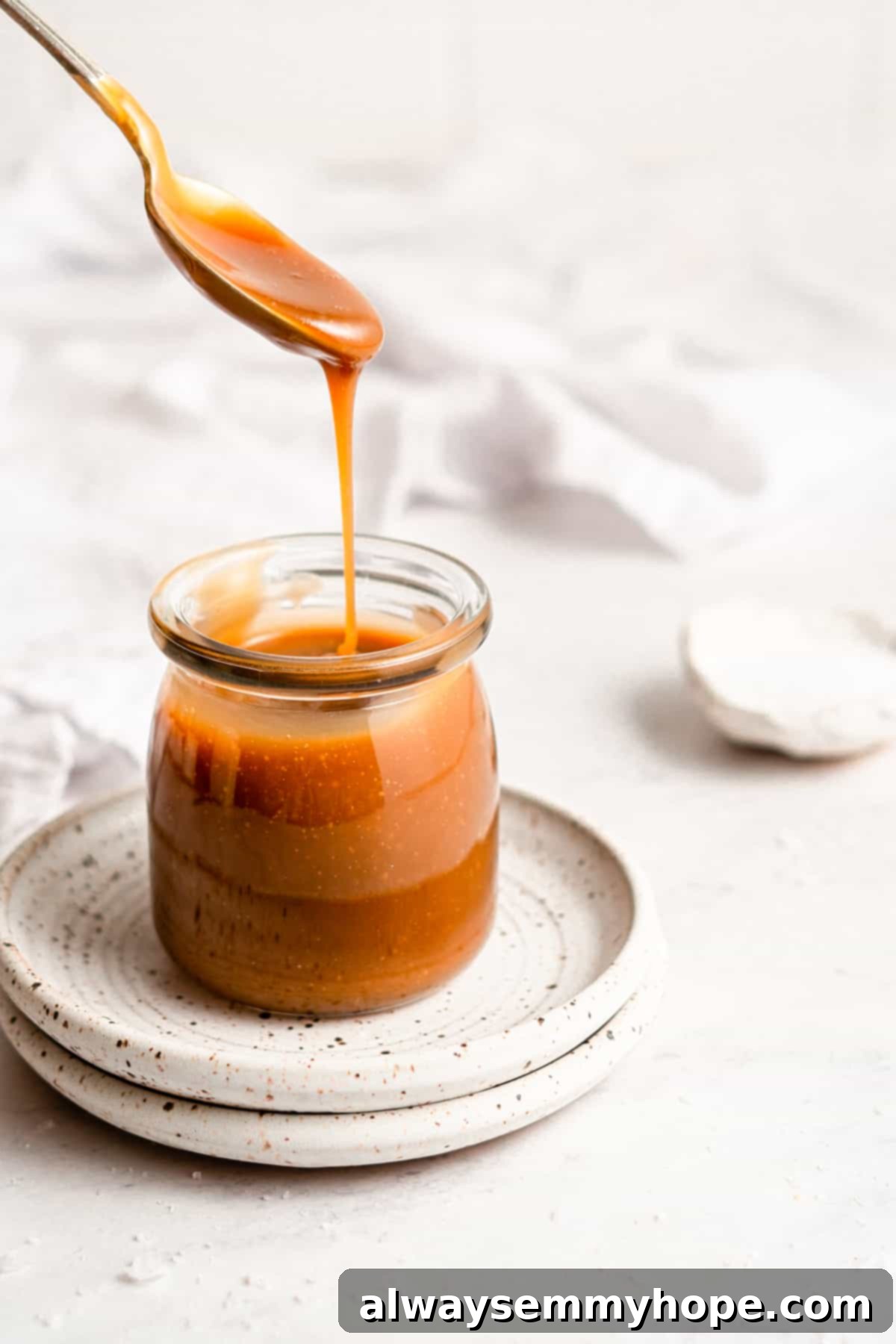 Simple Plant-Based Caramel 9 Homemade vegan caramel sauce filling a glass jar, showcasing its smooth texture and golden color.