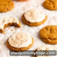 Pillowy Vegan Pumpkin Cookies 2 A mouthwatering image of vegan pumpkin cookies with creamy cream cheese frosting on parchment paper