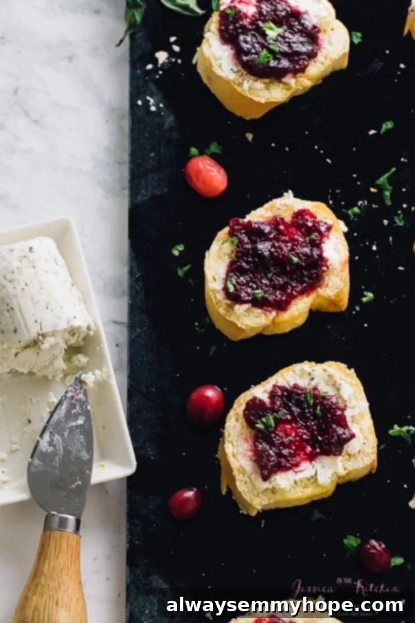 Top down shot of cranberry goat cheese crostinis beautifully arranged on a sleek black slate, ready to be served.