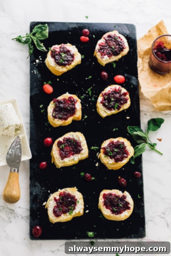 Overhead shot of goat cheese crostini artfully placed on a black slate, highlighting the rich colors.