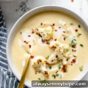Velvety Roasted Cauliflower Soup 14 Overhead view of Roasted Cauliflower Soup garnished with cauliflower, red pepper flakes, and thyme
