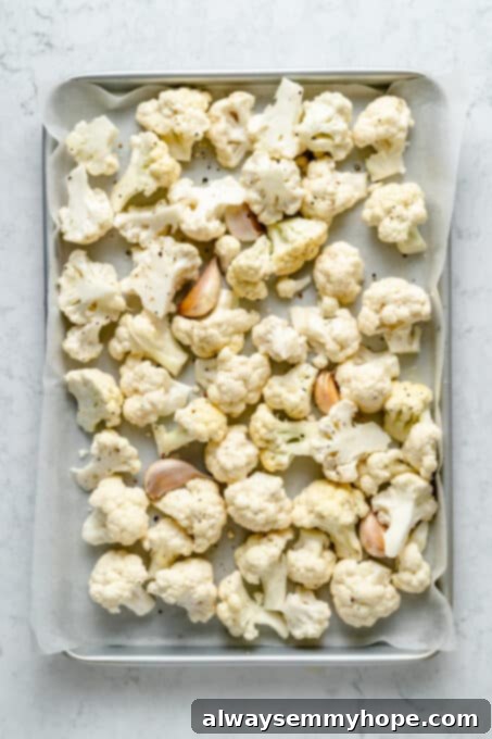 Velvety Roasted Cauliflower Soup 4 Cauliflower and garlic on parchment-lined baking sheet