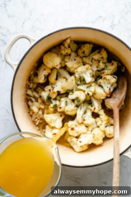 Velvety Roasted Cauliflower Soup 7 Pouring broth into pot with cauliflower and onions