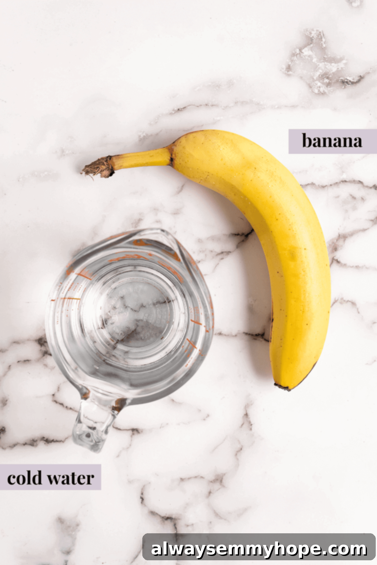 An overhead view of a peeled ripe banana and a glass of cold water, ready for blending.