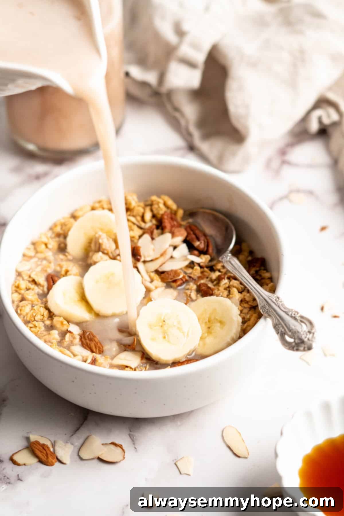 Homemade banana milk being poured over a bowl of crunchy cereal, ready for breakfast.