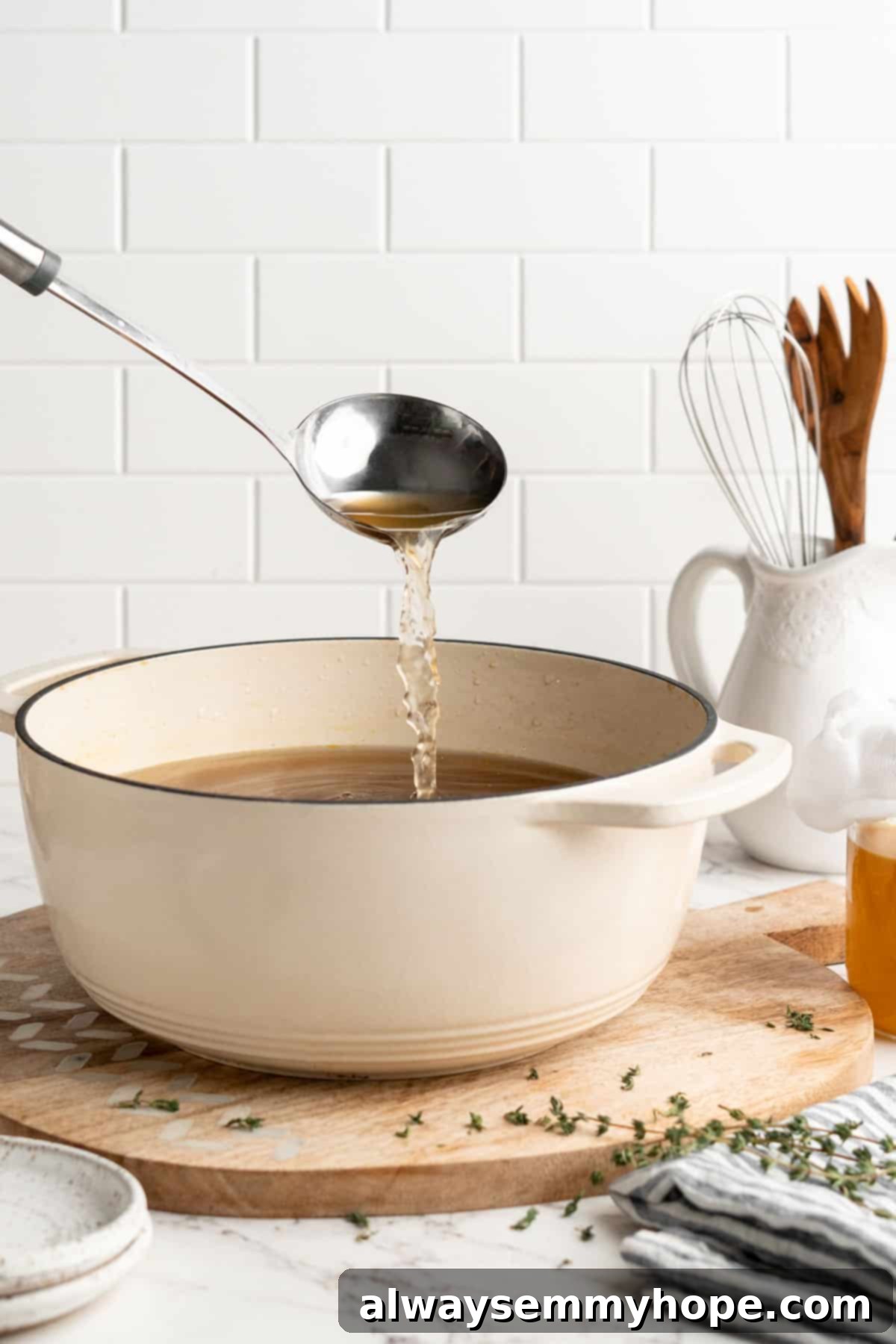 Learn how to make vegetable broth with veggie scraps. It’s the best broth you'll ever have, plus easy, cost-effective, and freezer-friendly! Ladle pouring vegetable broth into white enamel pot