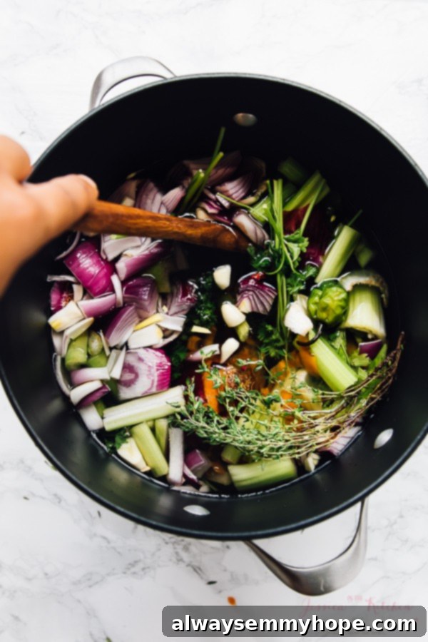 Wooden spoon stirring a vegetable broth in a black pot.