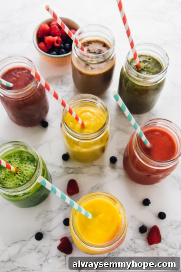 Top down shot of seven different smoothies in mason jars with straws.