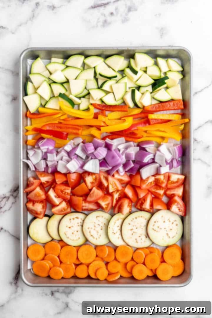 Easy Balsamic Roasted Vegetables 5 A colorful array of raw, chopped vegetables artistically arranged on a baking sheet, ready to be marinated and roasted.