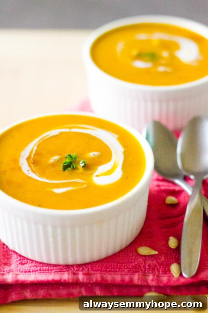Two ramekins with pumpkin soup and spoons on the side. 