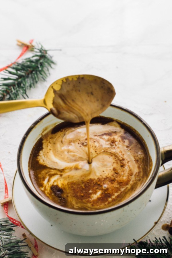A spoon scooping out some hot chocolate from a white cup. 