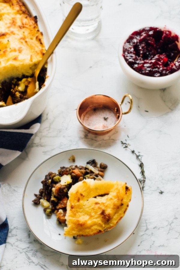 A portion of vegan shepherd's pie with cranberry sauce on the side. 