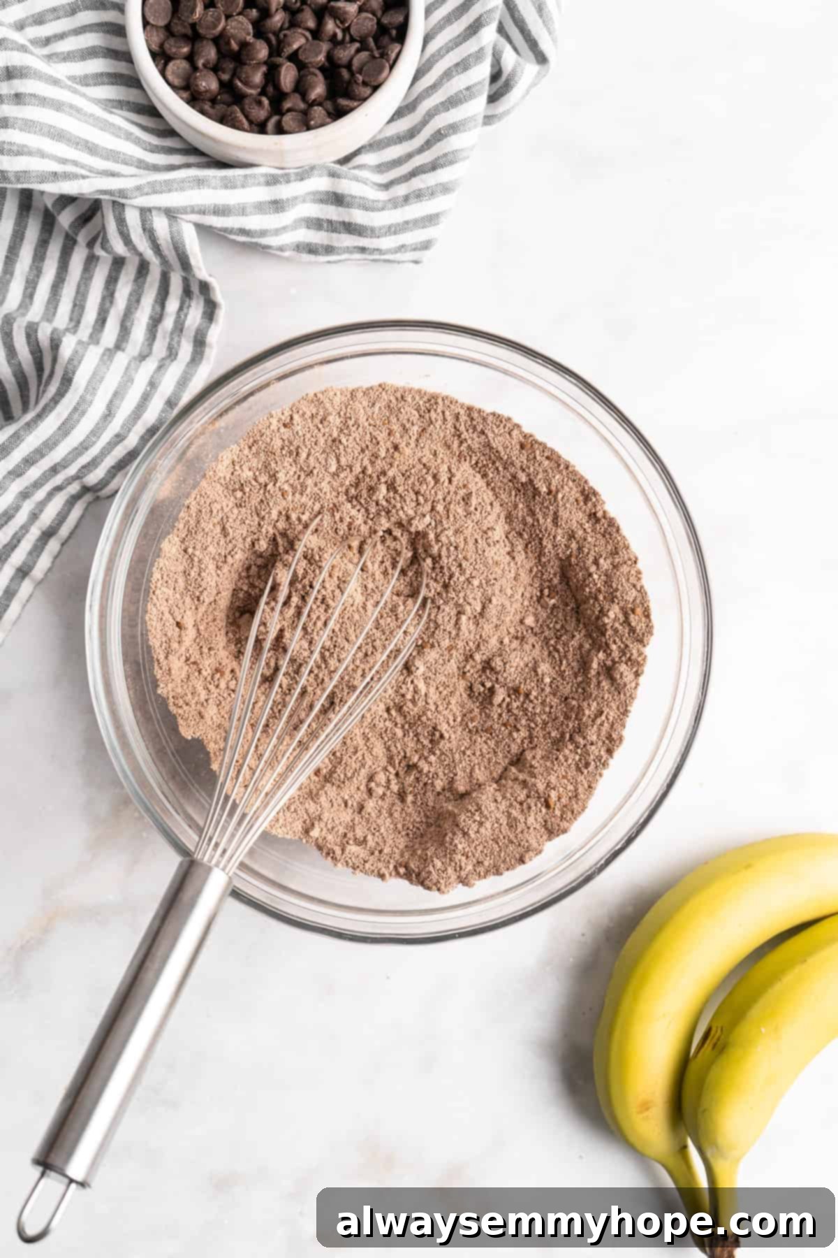 These easy chocolate banana muffins are moist, soft, and bursting with chocolate. They're made without refined sugar, gluten-free, and vegan! Whisking dry ingredients in glass bowl