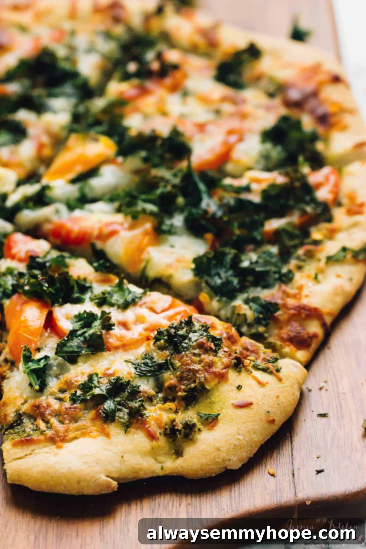 Closeup of kale pizza slices on wood board
