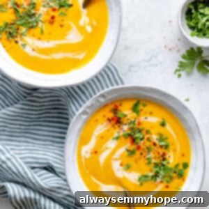 Golden Roasted Carrot Ginger Soup 13 Two bowls of roasted carrot soup on blue and white striped tea towel