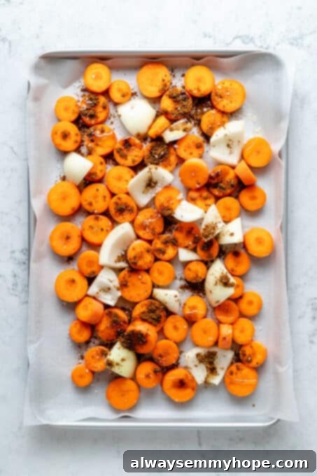 Golden Roasted Carrot Ginger Soup 4 Overhead view of carrots, onions, and garlic on sheet pan