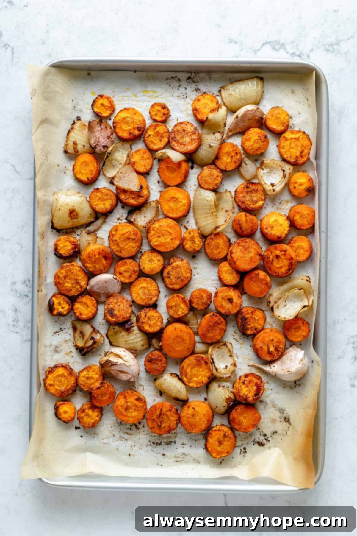 Golden Roasted Carrot Ginger Soup 6 Overhead view of roasted carrots, onions, and garlic on sheet pan