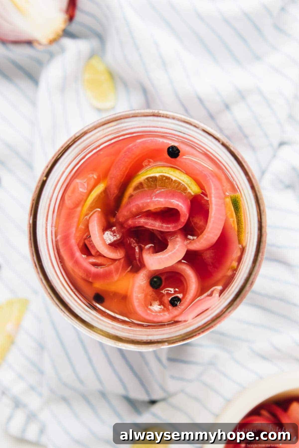 Overhead view of quick pickled red onions in a glass jar, ready to be served.