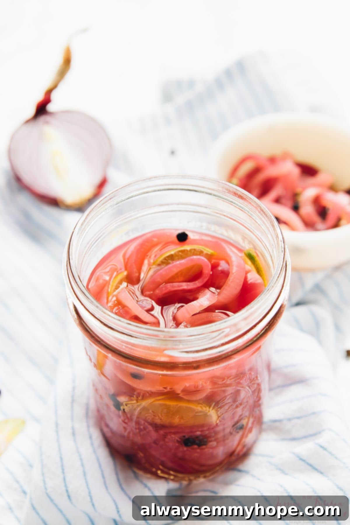 Beautifully pink pickled onions in a glass jar, ready for use.