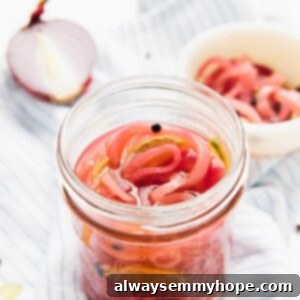 Beautifully pink pickled onions in a glass jar, ready for use.