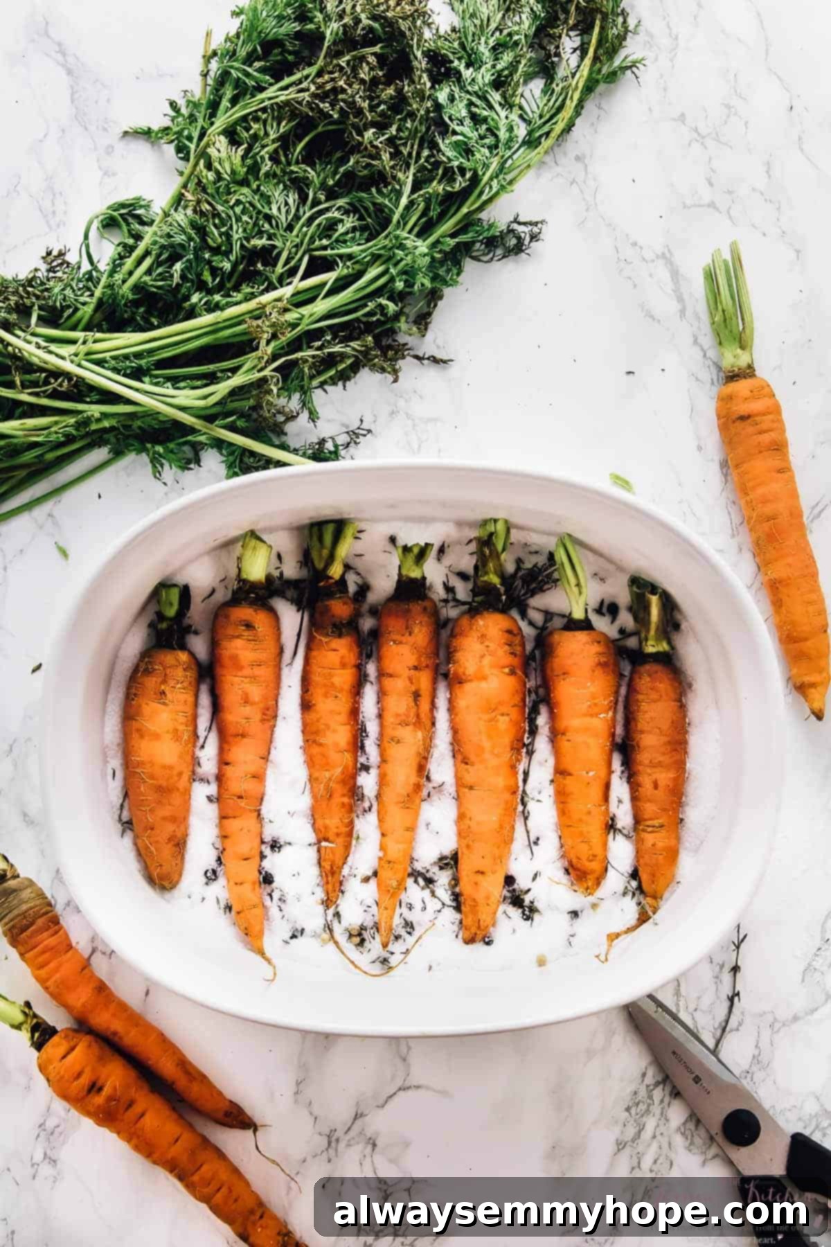 The Alchemy of Salt Roasted Carrots 5 Overhead shot of carrots fully submerged in a bed of salt within a baking dish, showing the roasting setup.