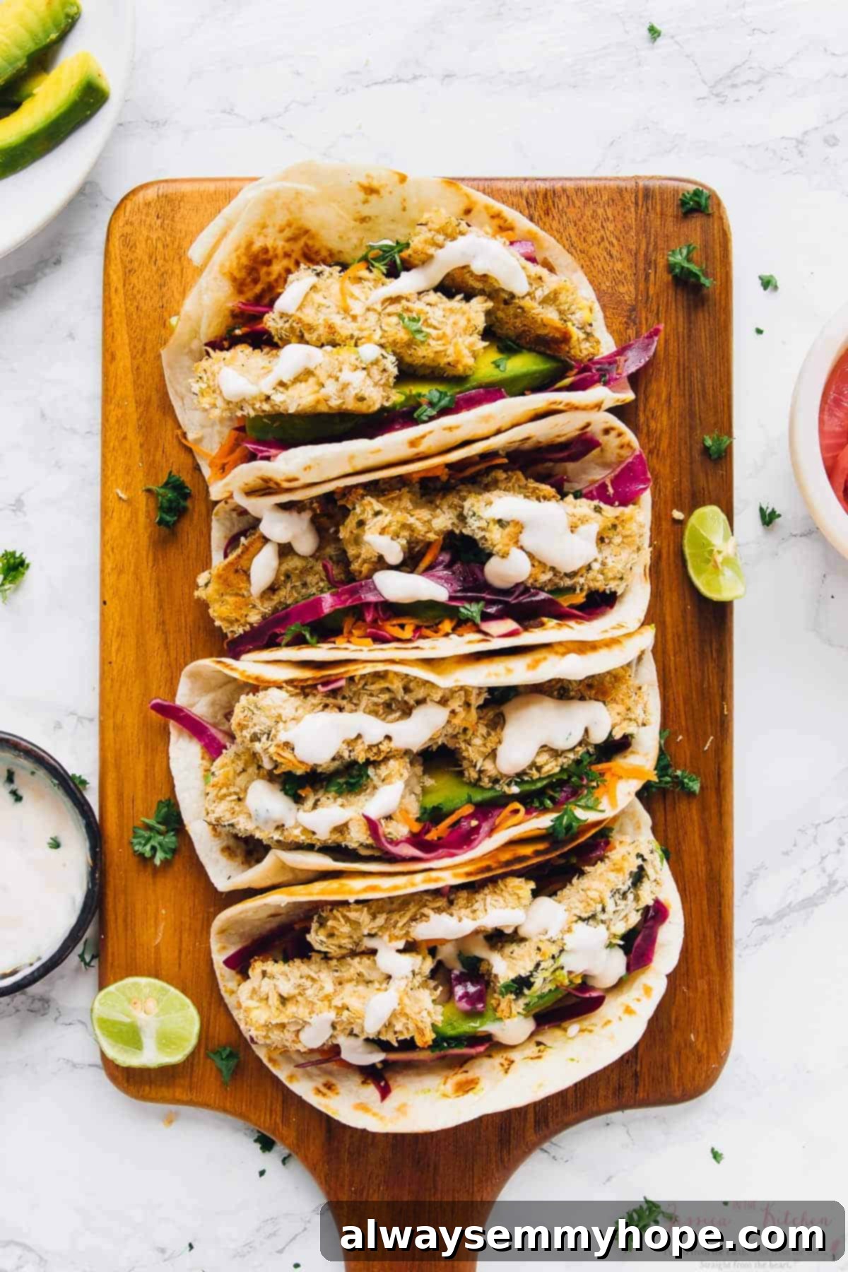 Overhead shot of four crispy zucchini tacos with vibrant fillings on a wooden board, showcasing their delicious appeal.