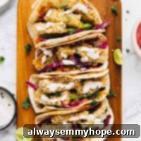 Overhead view of 4 crispy zucchini tacos lined up on a wooden board