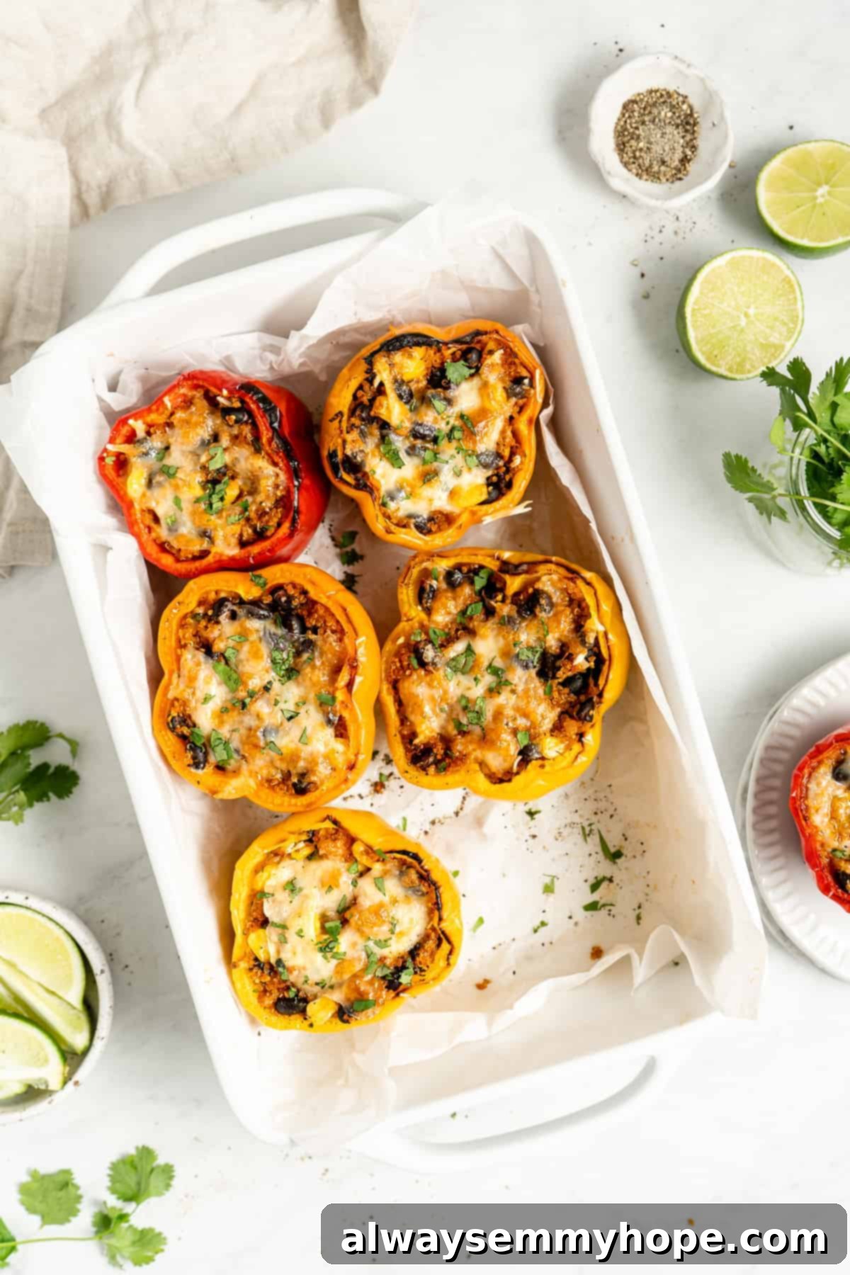 Five vibrant stuffed peppers, brimming with cheese, corn, black beans, and quinoa, beautifully presented.
