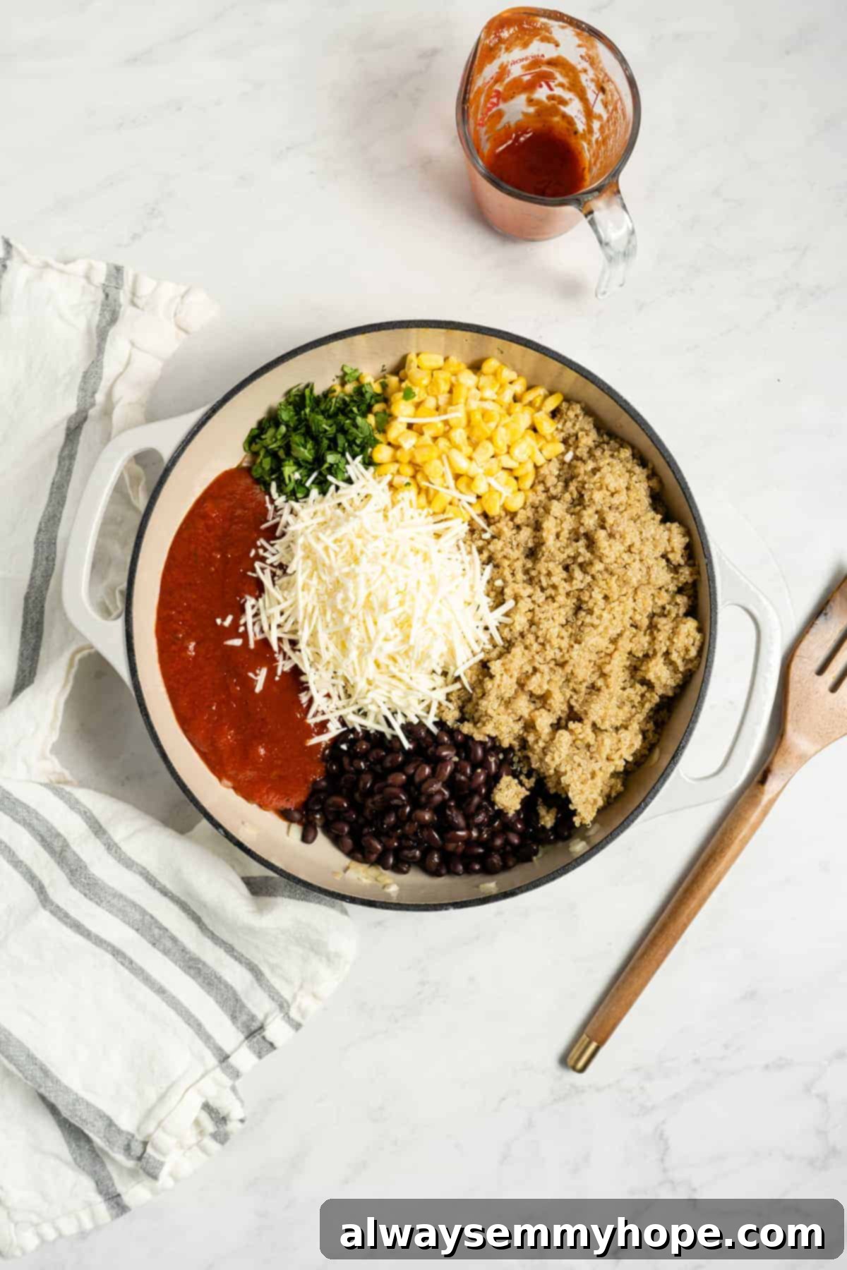 A colorful mixture of corn, black beans, quinoa, marinara sauce, and melting vegan cheese in a pan.