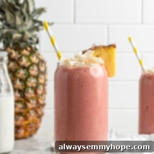 Tropical Strawberry Pineapple Bliss 2 Vegan Strawberry Pineapple Smoothie in a glass, garnished with fresh fruit and coconut