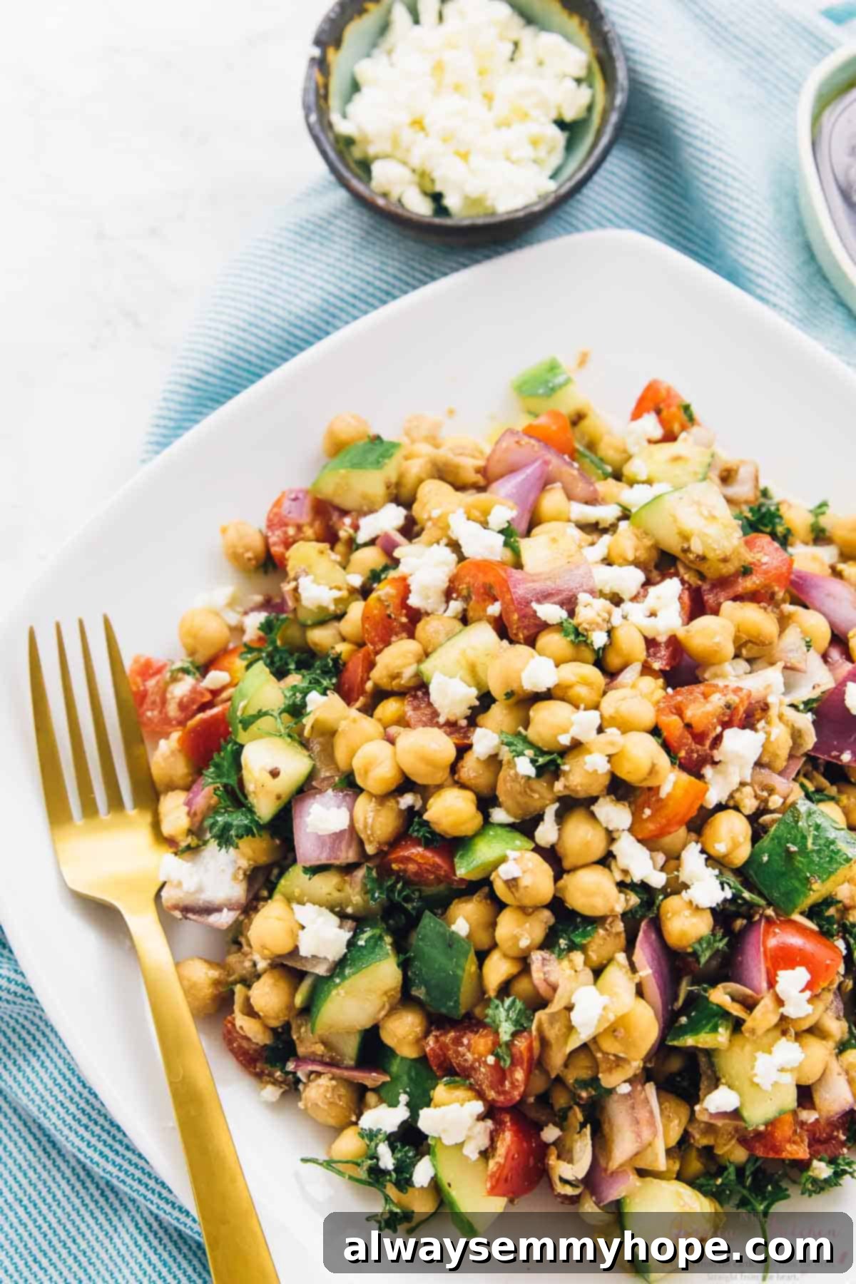 Stress-Free 15-Minute Meals for Your Craziest Weeknights 2 Mediterranean chickpea salad on a white plate with a gold fork on the side.