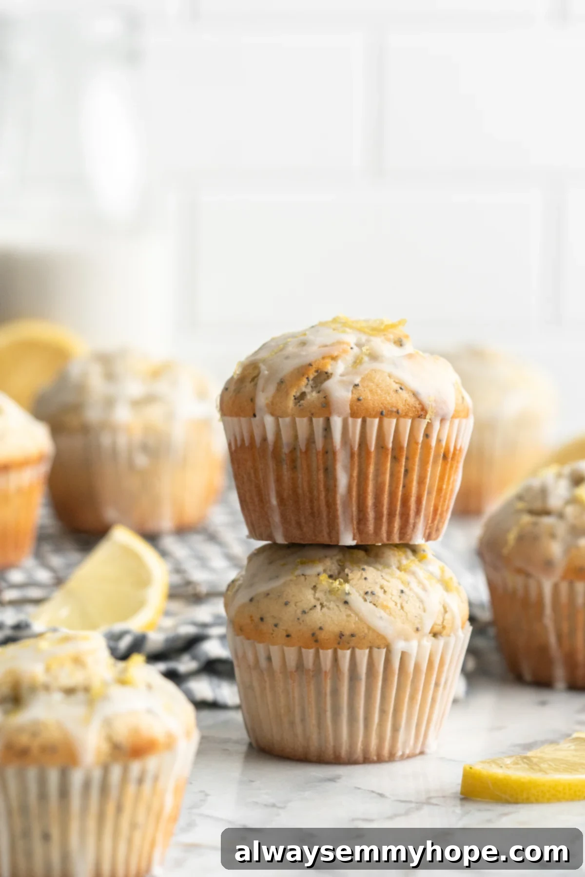 Stack of two perfectly baked, glazed vegan lemon poppyseed muffins ready to be enjoyed