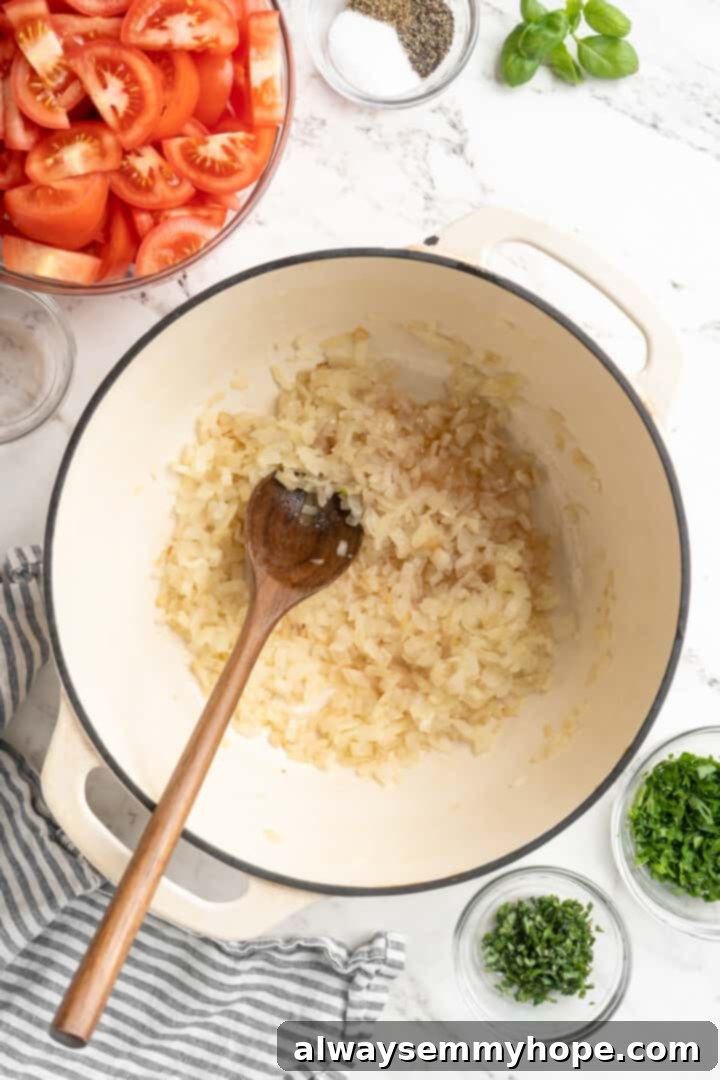 Onions gently cooking in a pot with shimmering olive oil, softening and turning golden for the flavorful homemade tomato sauce. Overhead view of onions being cooked and caramelized in a pot with olive oil for tomato sauce