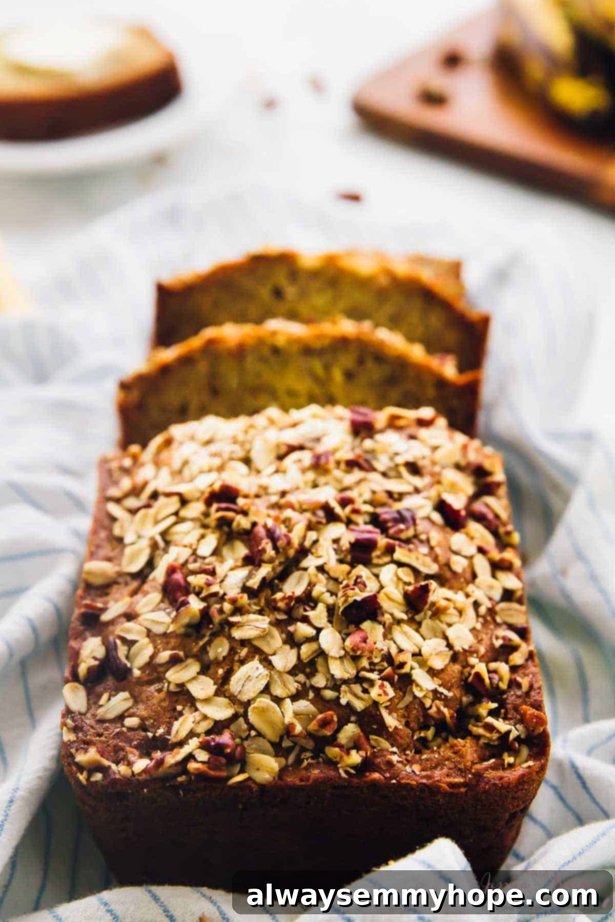 This is the best gluten-free vegan banana bread! Soft, moist, and easy to make with simple ingredients. Enjoy it with your favorite mix-ins! Sliced vegan gluten-free banana bread in flour sack towel