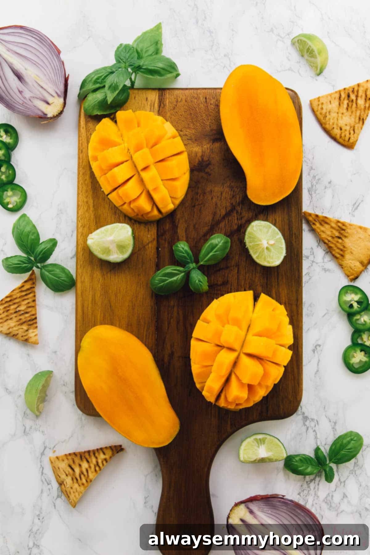 Freshly cut mangoes on a wooden cutting board, surrounded by vibrant basil leaves and zesty limes, ready for salsa preparation.