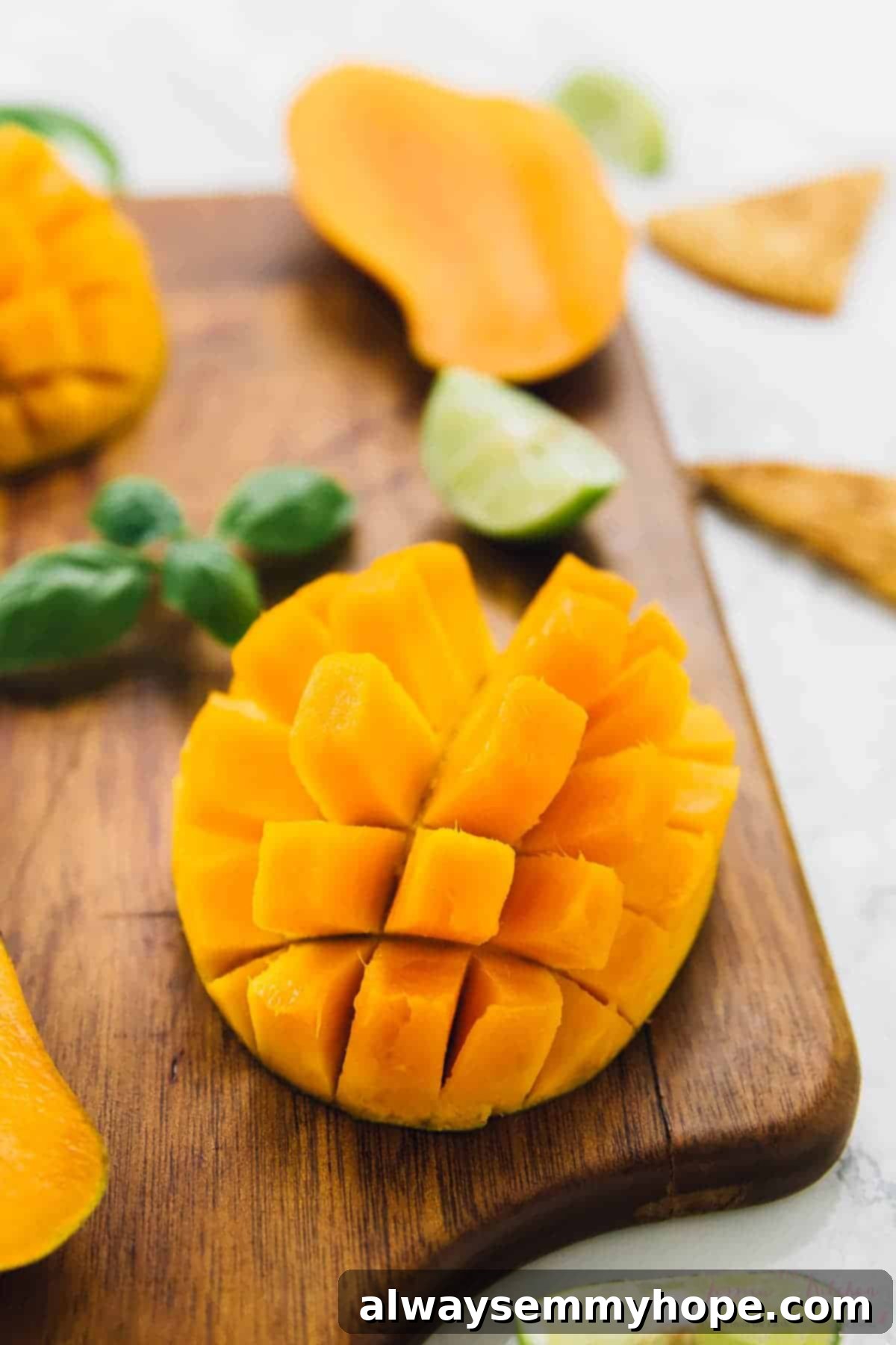 Close-up view of perfectly diced ripe mango on a wooden cutting board, highlighting its vibrant color and texture.