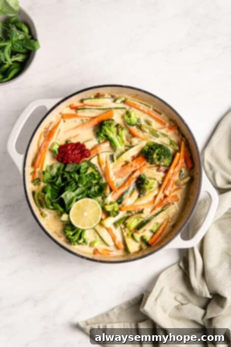 Effortless Thai Green Curry 11 Crispy vegetables immersed in a luscious curry sauce, with a fresh lime wedge ready for squeezing.