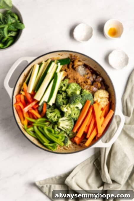 Effortless Thai Green Curry 8 Seasonings lightly sprinkled over the chopped vegetables in the pan, preparing for a stir.