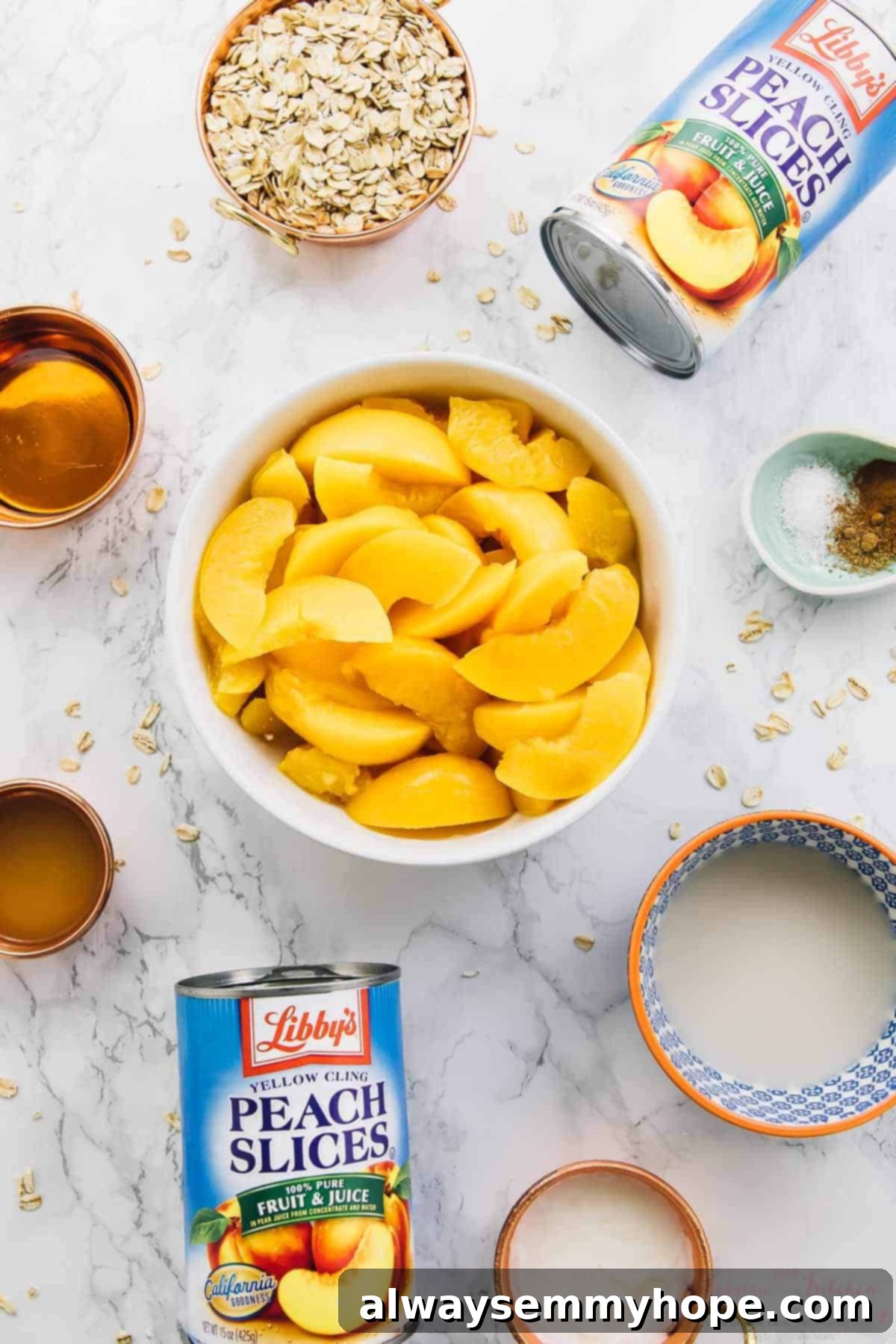 Overhead view of fresh ingredients for breakfast peach cobbler laid out on a white surface.