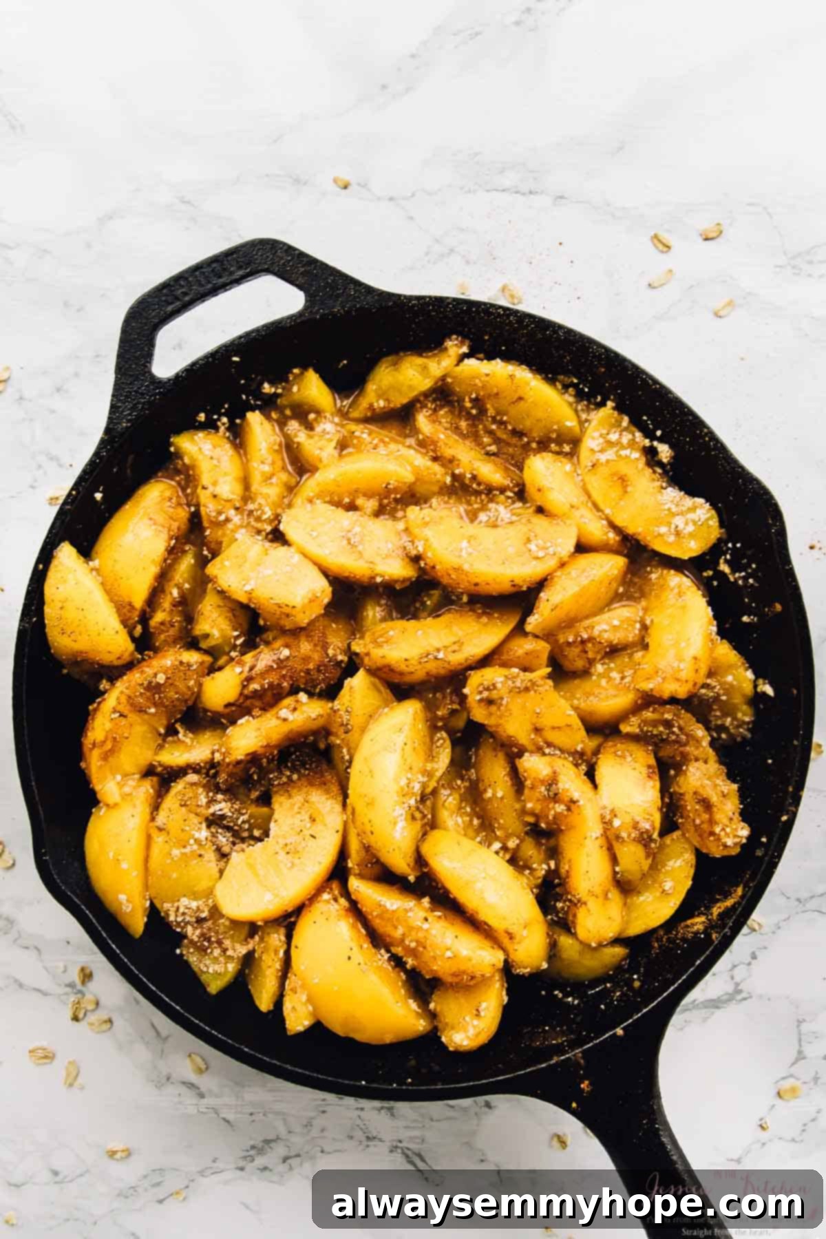Overhead view of peach filling for cobbler in a cast iron skillet, ready for the topping.