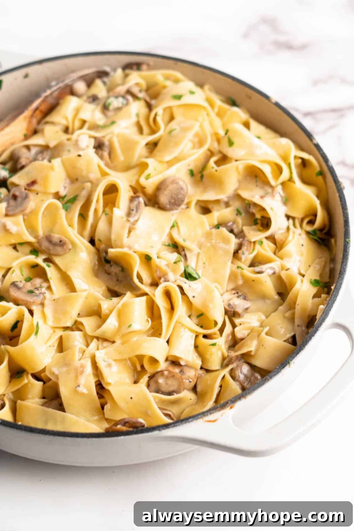 Garlic Mushroom Pasta simmering in a pan, showcasing the rich, creamy sauce before serving.