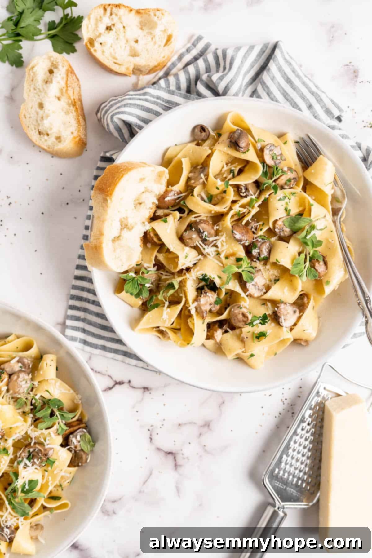 Overhead view of Creamy Garlic Mushroom Pasta served in white bowls with crusty bread on the side.