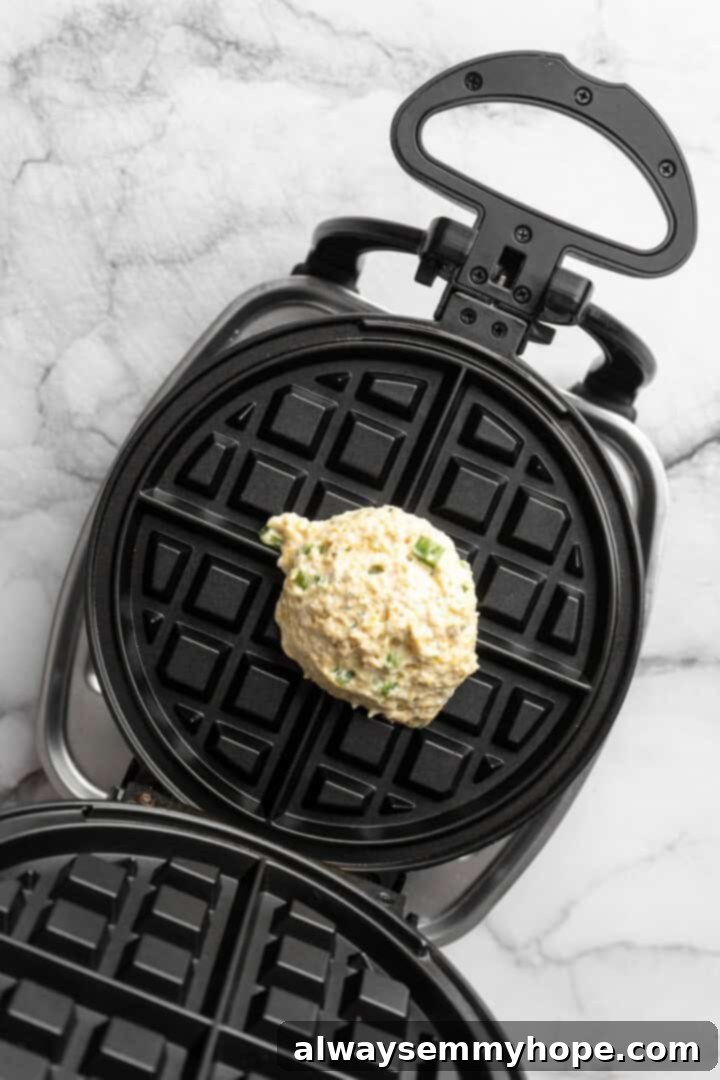 Overhead view of cornbread waffle batter in waffle iron