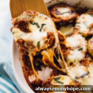 Baked eggplant scooped out of a baking dish with a spatula