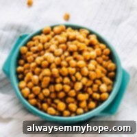 Chickpeas in a blue bowl on a striped cloth.