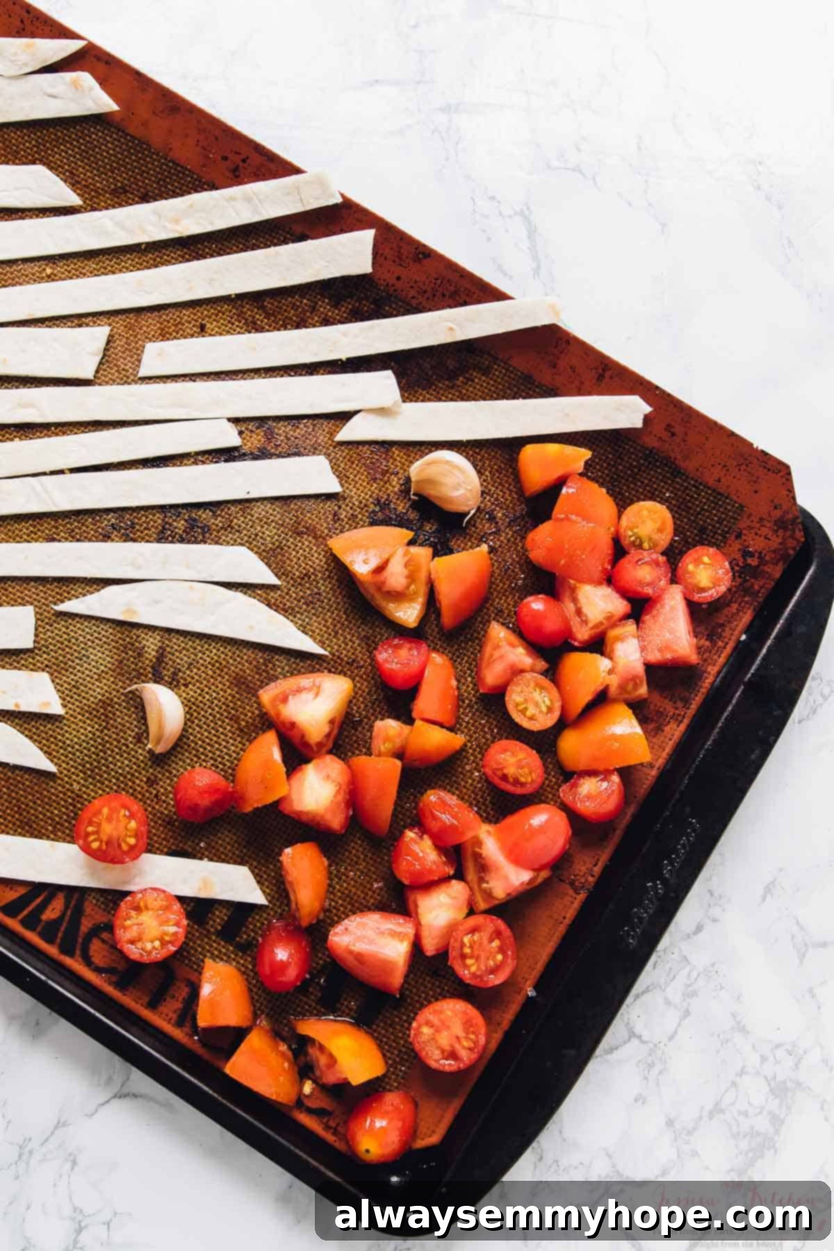 Loaded Taco Salad Bowl with Fresh Lime Crema Drizzle 4 Diced tomatoes and tortilla strips on a baling sheet.