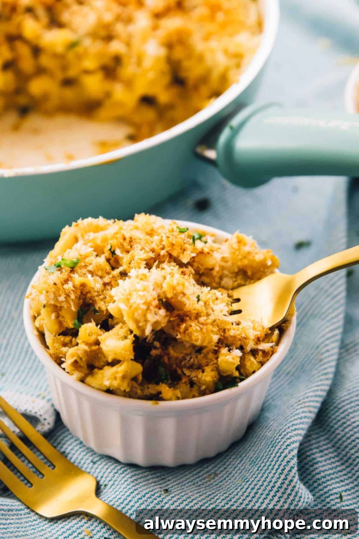Fork scooping out mac and cheese from a white ramekin.