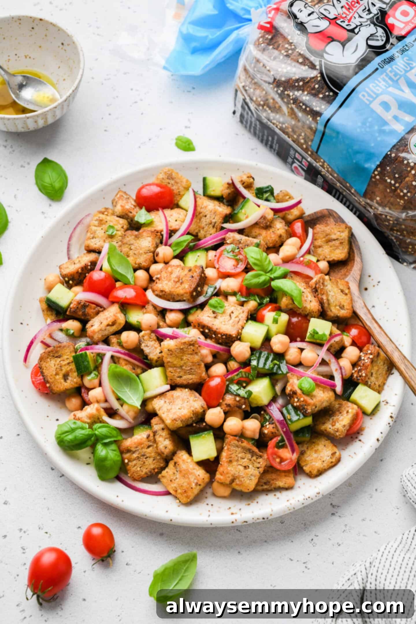 Rustic Chickpea Panzanella 5 Overhead view of chickpea panzanella salad on platter with bread in the background